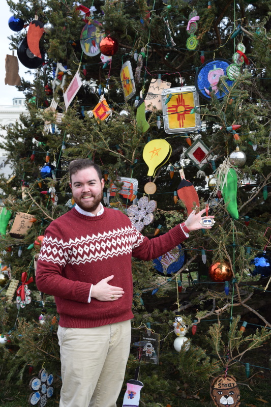 Samuel Holliday, Manager of Communications and Administration, displays the 2019 Ornament