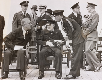 British Prime Minister Winston Churchill and U.S. President Franklin D. Roosevelt met for the Atlantic Charter Conference in August 1941 aboard their ships in Placentia Bay, Newfoundland. Here they gather with staff on the deck of the HMS
Prince of Wales.

Credit: Library of Congress, Prints & Photographs Division, NYWT&S Collection, [LC-DIG-ds-11162]